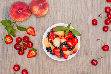 Delicious fruit salad on a wooden background. Top view.