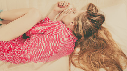 Young woman lying on bed wearing pajamas