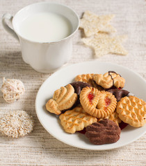 Plate with tasty Christmas homemade cookies and milk