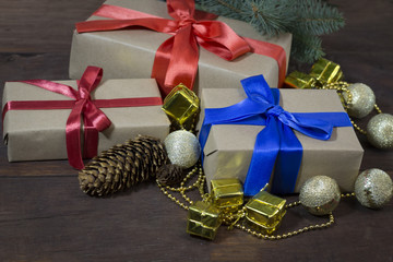 Gift boxes, gold balls, decorative gifts and beads, a branch of fir, cones