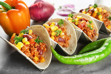 Chili con carne with tortillas and vegetables on kitchen table