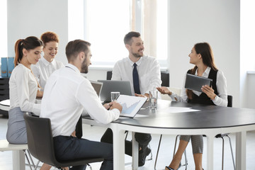 Team of young professionals conducting business meeting in office