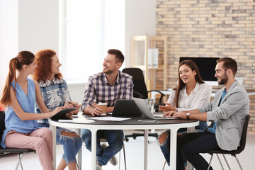 Team of young professionals conducting business meeting in office