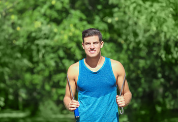 Young man with jumping rope in park