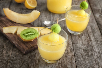 Glasses of fresh melon smoothie on wooden table