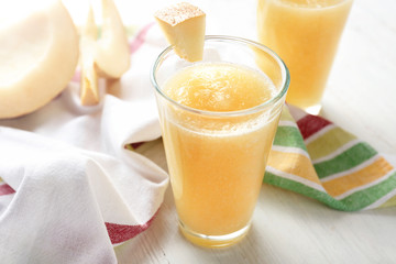 Glass of fresh melon smoothie on table