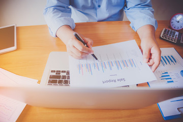 Working process startup. Businessman working at the wood table with new finance project. Modern notebook on table. Pen holding hand
