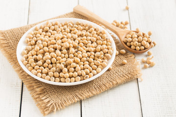 White wood floor with wooden cup with soybean,soybeans in white bowl with wooden spoon on table wooden