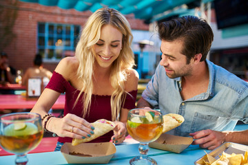 romantic couple eating street tacos at outdoor mexican restaurant