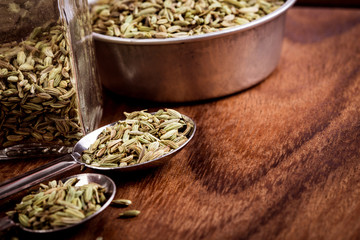 close up  fennel seed in  spoon on brown wooden table