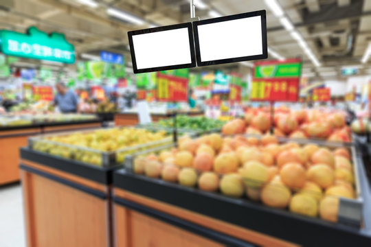 Blank supermarket TV screen and blurred supermarket fruits background