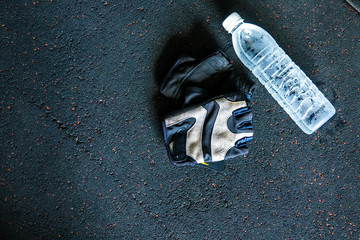 Cool water drinking on floor in fitness gym. Selective focus.