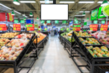 Blank supermarket TV screen and blurred supermarket fruits background