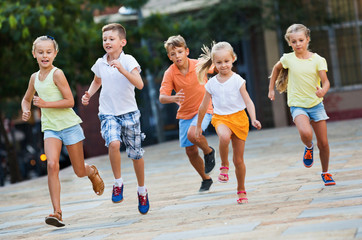 Group of  children running outdoors in city street