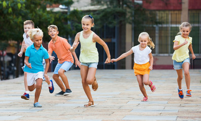 Group of  children running outdoors in city street