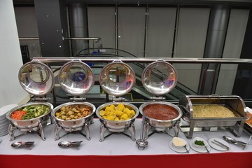 food, catering, self-service and eating concept - Buffet food serving on metallic tray. Prepare for wedding party. Metal buffet heated trays with food on tables at banquet event celebration