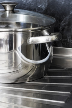 Shiny stainless steel saucepan on the kitchen sink.