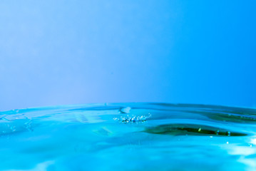 Obraz premium drop of water falling in blue water and blue background.
