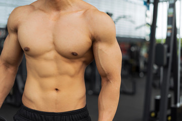 Obraz na płótnie Canvas Fitness man showing muscular body in gym