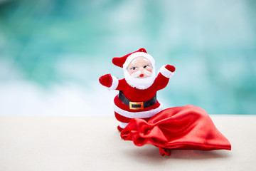 Christmas concept background, Santa claus with red bag over blurred blue background