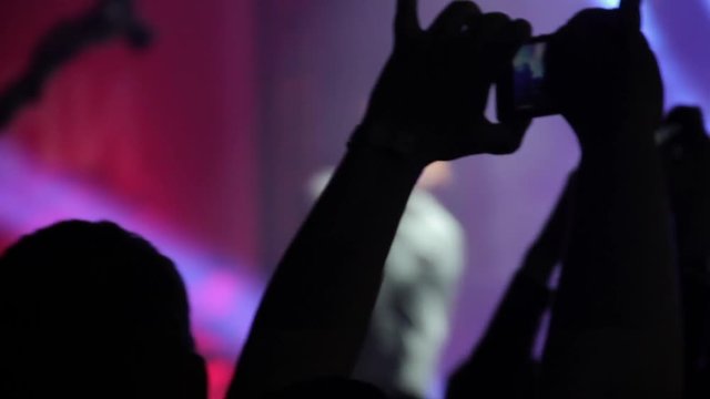 Hand with a smartphone records live music festival and taking photo of concert stage live concert luxury party in facebook live