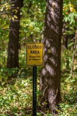 yellow sign on post in woods no hunting