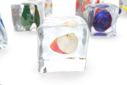 Apple in ice cube isolated on white with depth of field effects. Ice cubes with fresh berries. Berries fruits frozen in ice cubes, 3D rendering