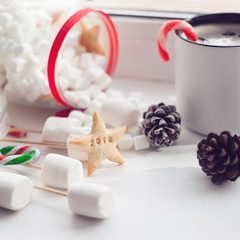 Christmas or New Year composition with hot coffee, marshmallows, decorated with sweets, spices, cone on white background