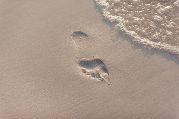 A trace of human foot in the sand. Beach.