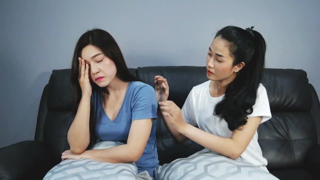 4k of Two sad female friends holding each other in sofa