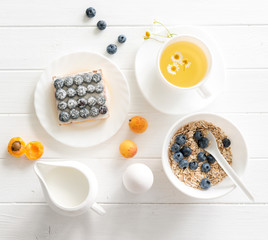 Fitness breakfast: granola with berries and fruits, eggs and tea.
