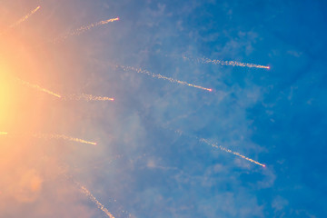 Yellow sparks of festive fireworks in the blue sky