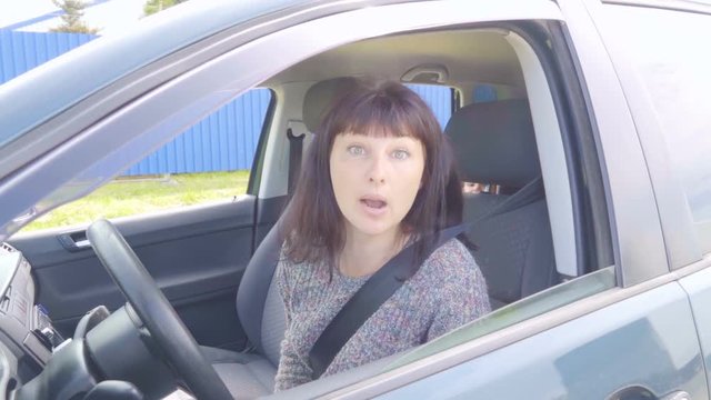 Young angry woman in perplexity sitting in the car.Slow Motion.