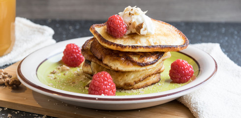 homemade pancakes with pieces of walnuts, honey and fruit