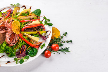 Salad with meat and salad leaves. On a wooden surface. Top view. Free space for your text.