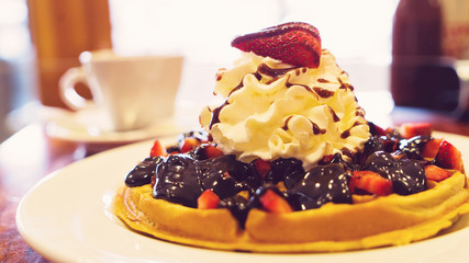 Delicious homemade waffle desert with fruits and whip creame