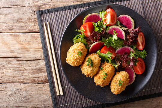 Japanese potato korokke and fresh vegetables close-up. horizontal top view