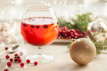 Christmas still life with cranberriy punch and blurred snow outside the window. Festive and bright