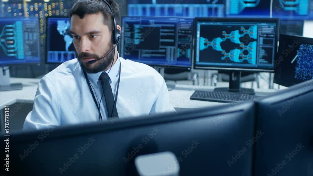 Poster In the System Monitoring Room Dispatcher Speaks into Headset, Observers Proper Functioning of the Facility. He's Surrounded by Screen Showing Technical Data. 