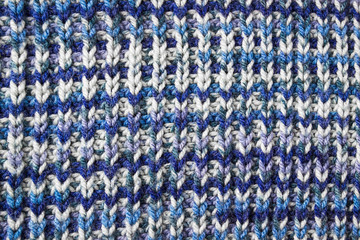 Blue knitted background. Knitted texture. A sample of knitting. Knitting Pattern.
