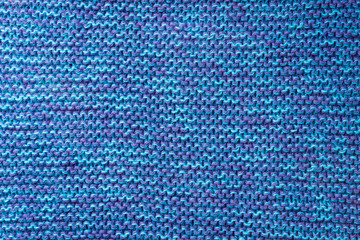 Blue knitted background. Knitted texture. A sample of knitting. Knitting Pattern.