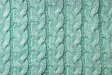 Turquoise knitted background. Knitted texture. A sample of knitting. Knitting Pattern.