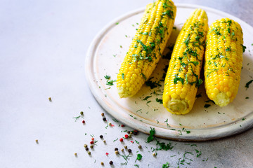 Boiled corn with spices on grey light concrete background. Copy space