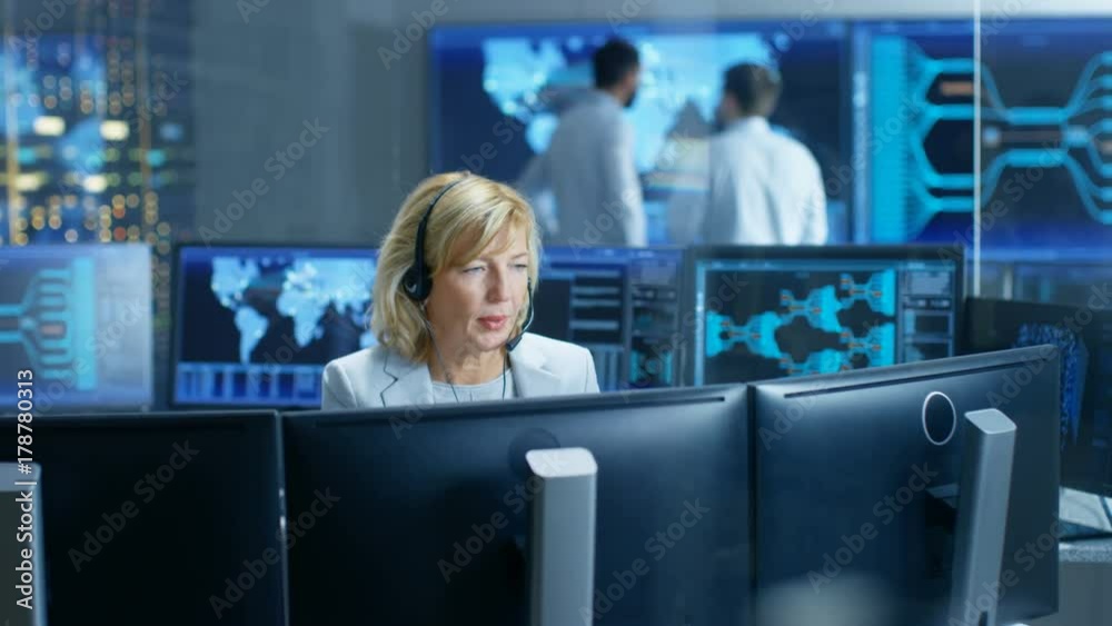 Aufkleber System Monitoring Room Female Dispatcher Control Correct Functioning of the System. In the Background People Working with Interactive Map. Shot on RED EPIC-W 8K Helium Cinema Camera.