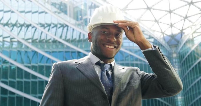 An engineer with a security helmsman, looks proud of the success of his construction project. Concept of: engineering, buildings, business, dream, success