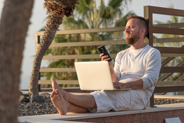 Young man with laptop at sunset