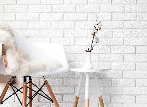 A part of modern minimalist interior with chair covered with white fur
