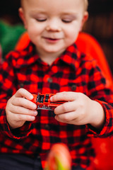 Little boy in red shirt plays sitting in the room