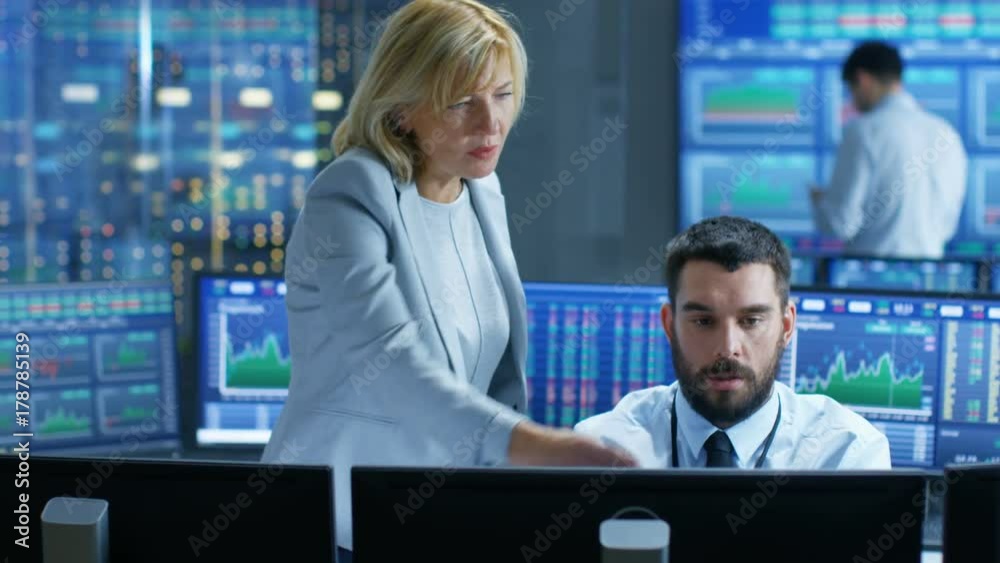 Aufkleber in the stock market firm chief executive talks with professional trader. they're surrounded by scree