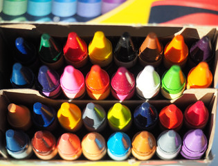 Multi colour crayons neatly stacked inside a box